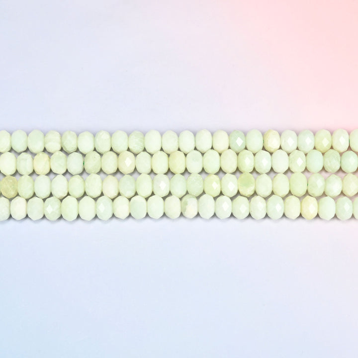Two strands of new jade faceted rondelle beads running straight across a plain background.