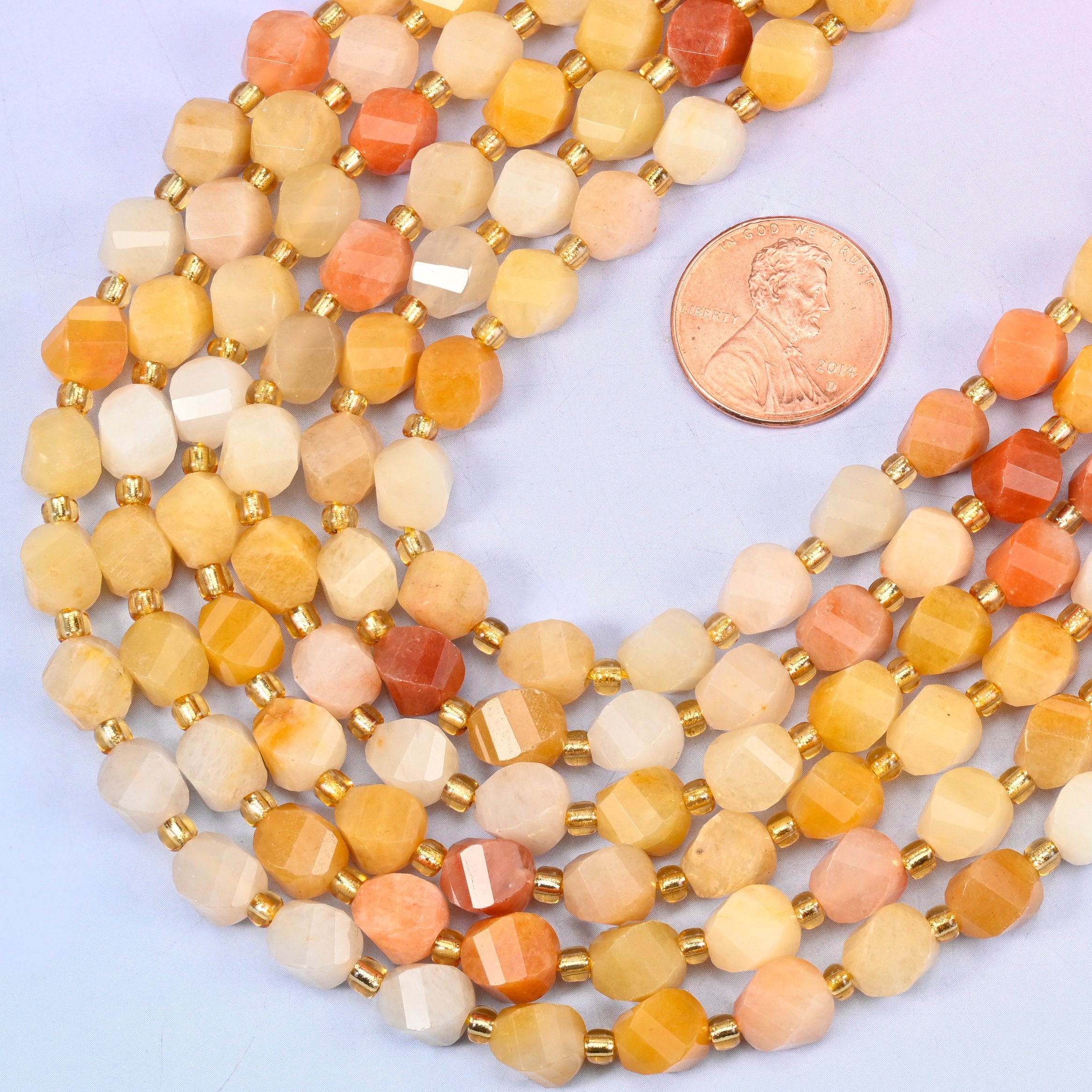 Gold silk jade yellow jade beads with small gold spacer beads set between each 8mm faceted bead