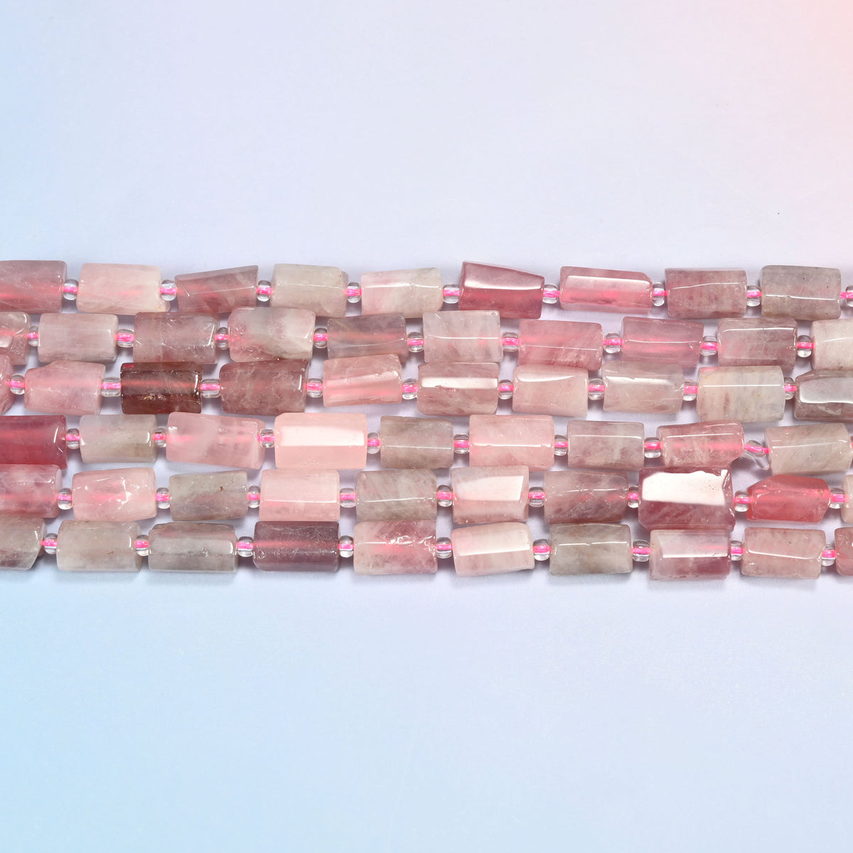 Madagascar multi color rose quartz faceted tube beads in straight horizontal rows with hot pink glass seed bead spacers between.