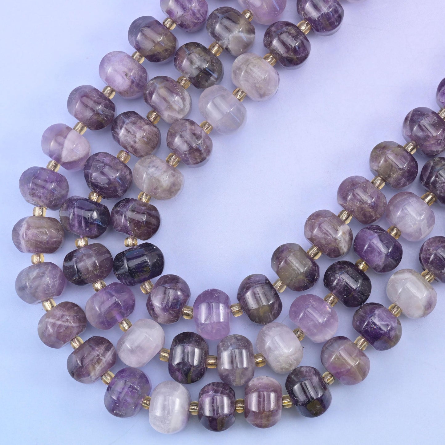 Strands sweeping into a curve, deeper grape beads alternating with near-clear pale ones