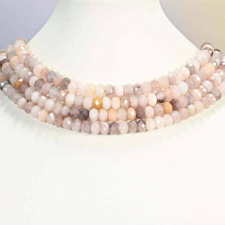 Lavender quartz faceted rondelle strands arranged as a layered collar on a white display bust, pastel lilac and peach tones