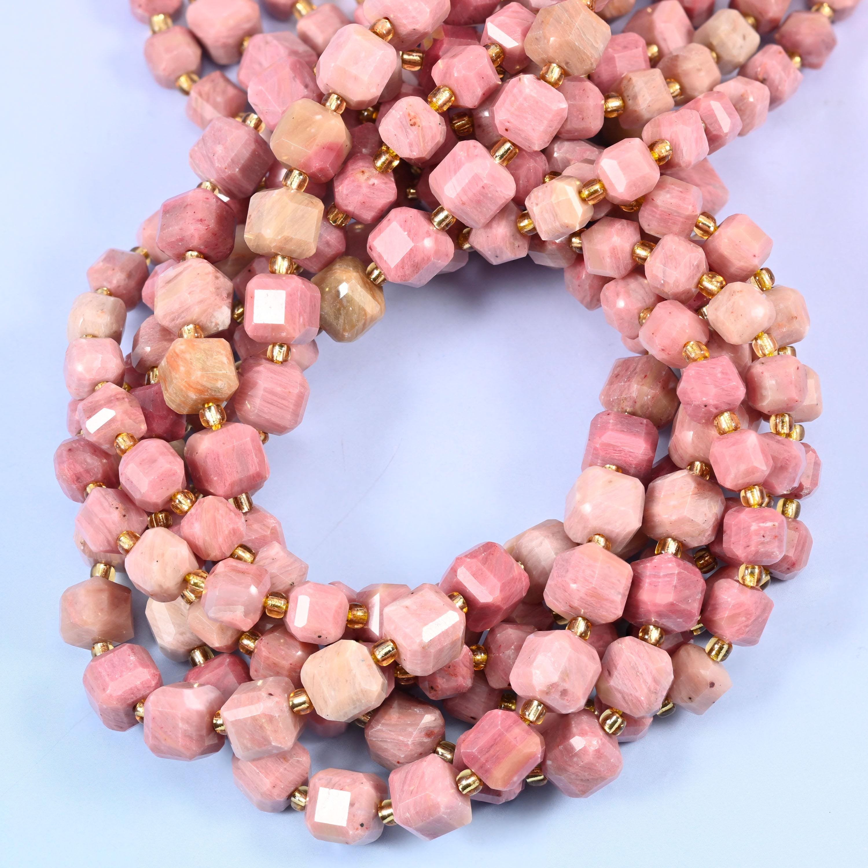 Dusty rose cubes clouded with oatmeal cream and fine darker veining, faceted at the corners so each flat face picks up its own highlight.