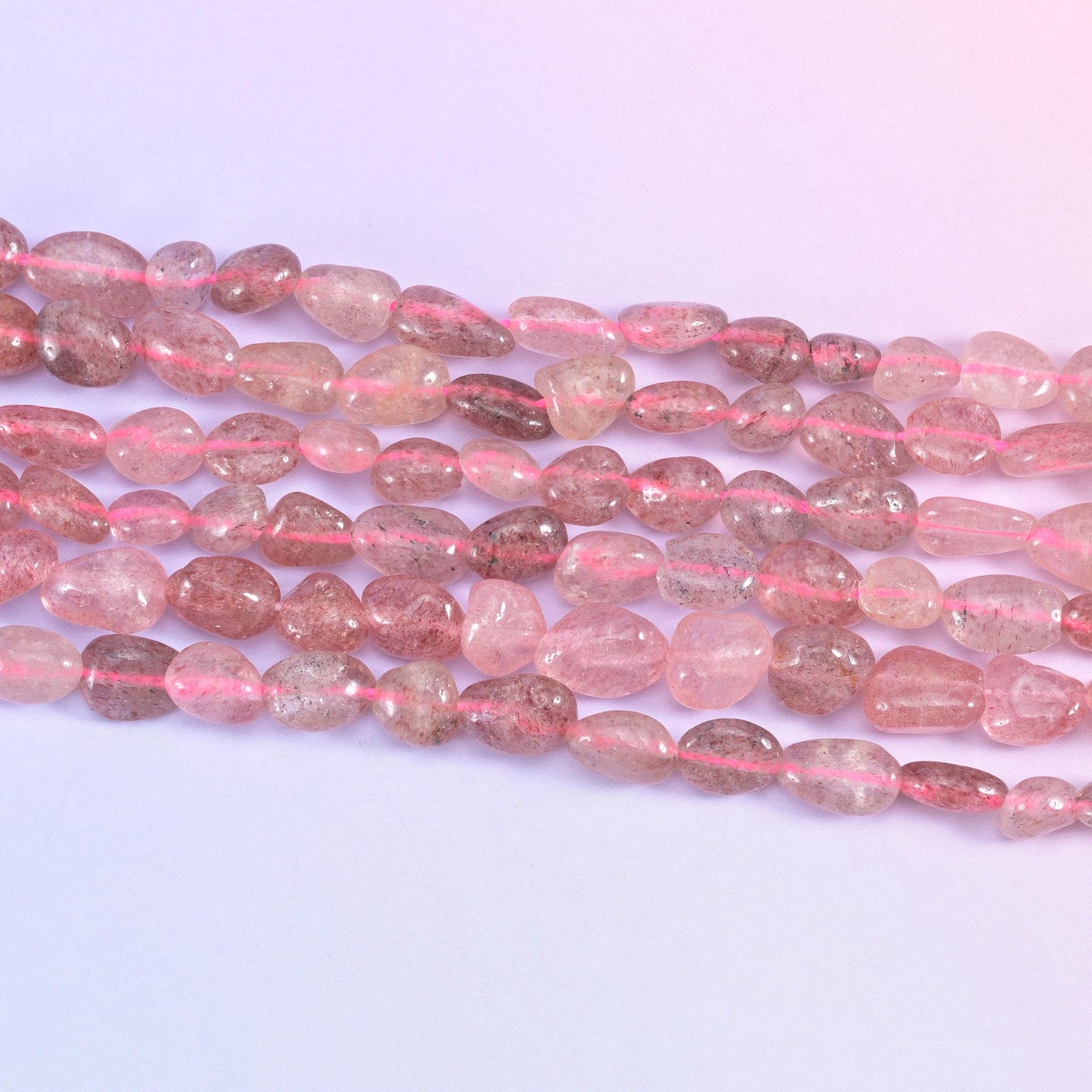 Strawberry Quartz Pebble Nugget Beads in translucent dusty rose with reddish-brown inclusions