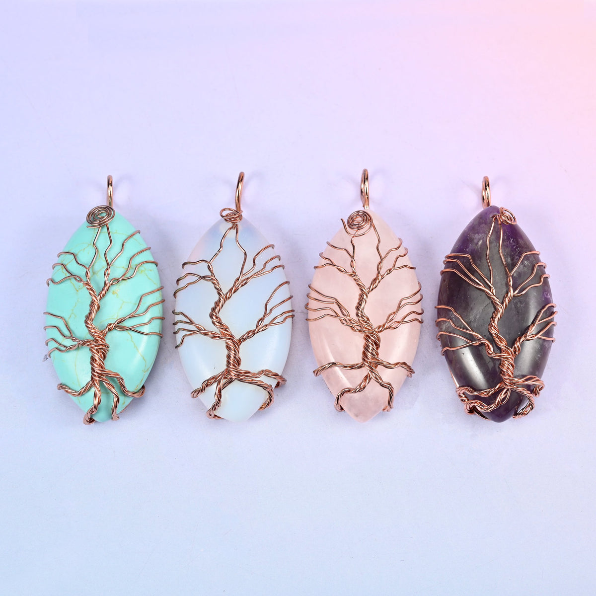 Four colour options of the Oval Crystal Pendant with Copper Wired Tree lined up in a row: mint green, milky white, blush pink and deep purple.