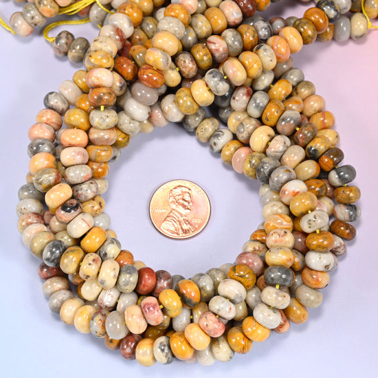 Multiple strands of Crazy Agate beads gathered together on a lavender surface, loose ends visible.