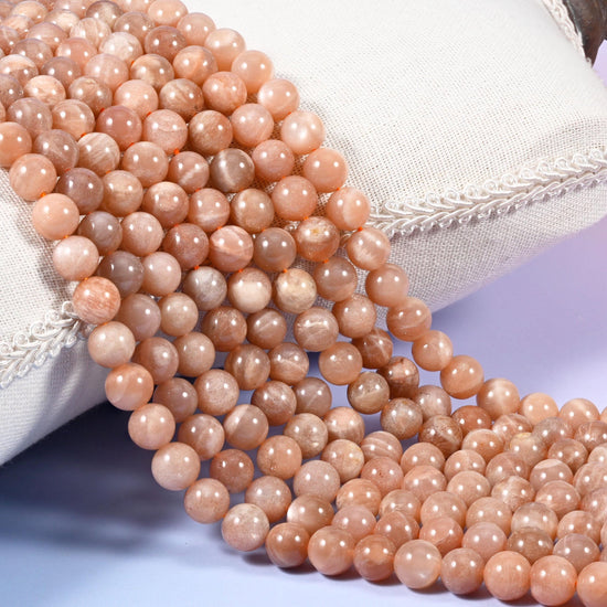 Peach Moonstone Smooth Round Beads in warm apricot fading to sandy beige.