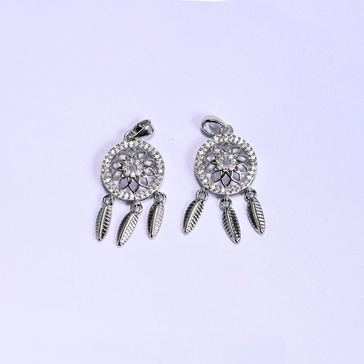 Dream Catcher Zirconia Charms in silver tone, two platinum plated pendants with openwork floral medallions, zirconia pave rims and three feather dangles each.