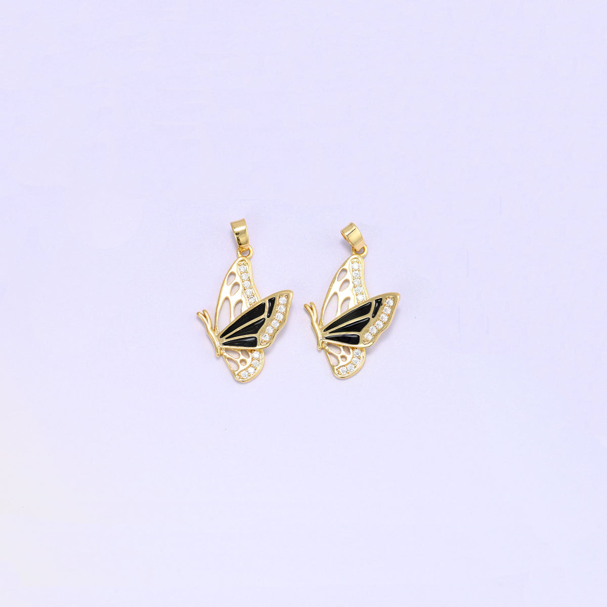 Black colourway of the flying butterfly charm pendant, a pair of gold plated charms with black enamel wings and clear zirconia set along the wing edges.