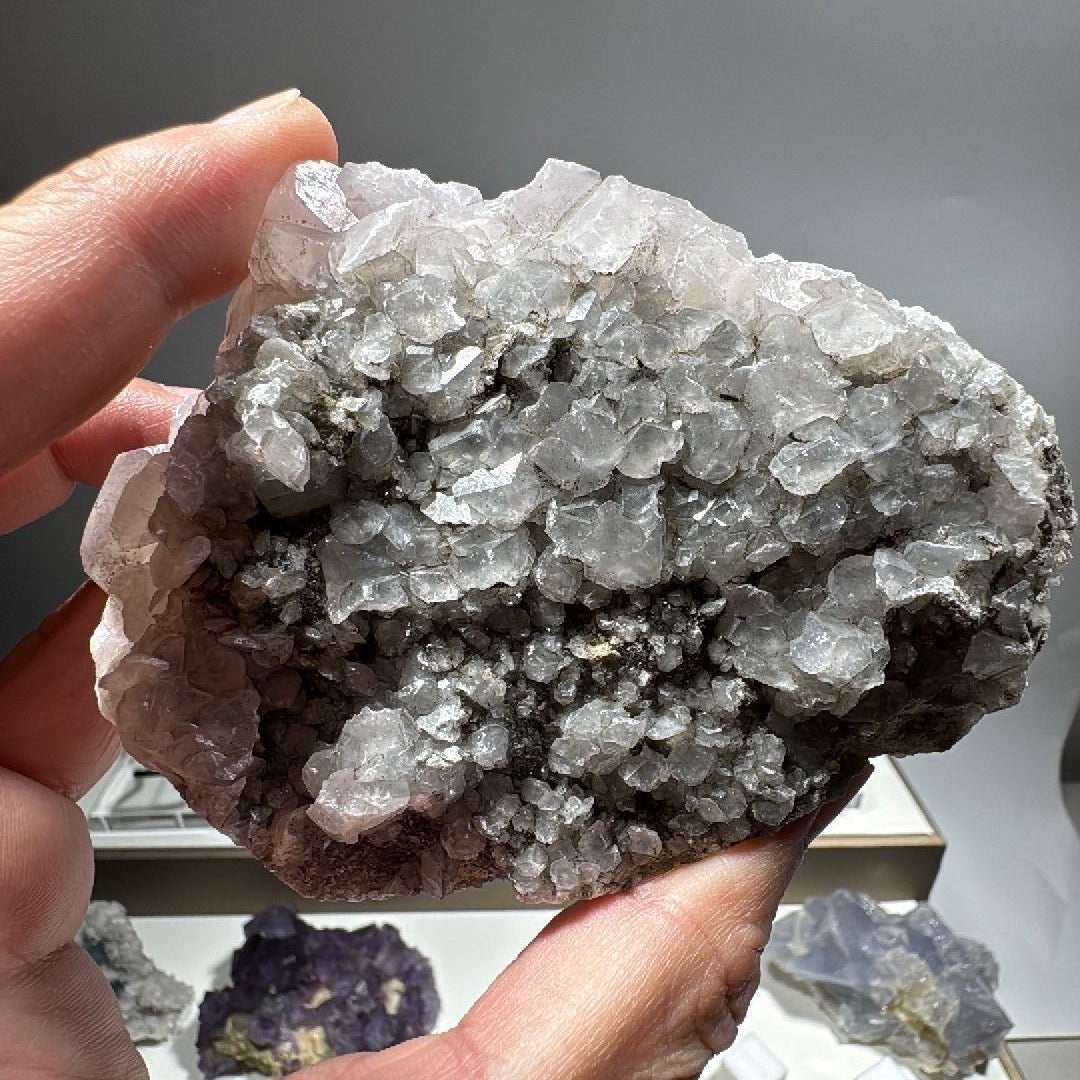 Reverse side of the calcite specimen showing grey rock matrix and druzy crystal cover