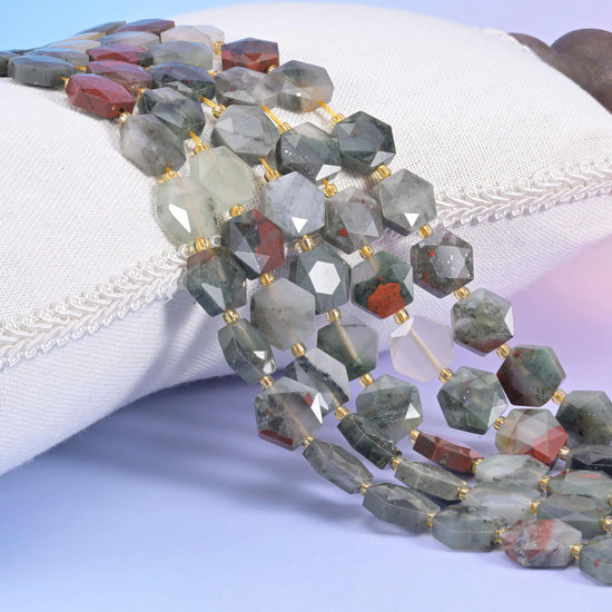 African Bloodstone faceted hexagon strands resting on a white cushion