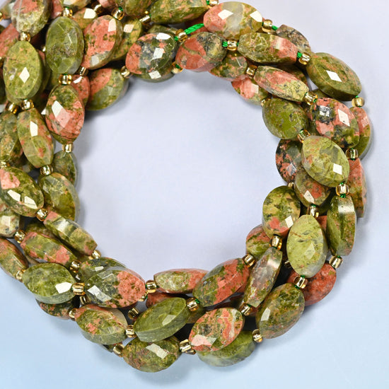Unakite faceted flat oval beads coiled into overlapping loops, whole strands of green and pink stone