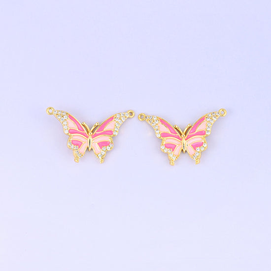 Enamel butterfly double connector pendants in pink, two gold plated charms with hot pink and blush wing stripes and a loop at each upper wing tip.