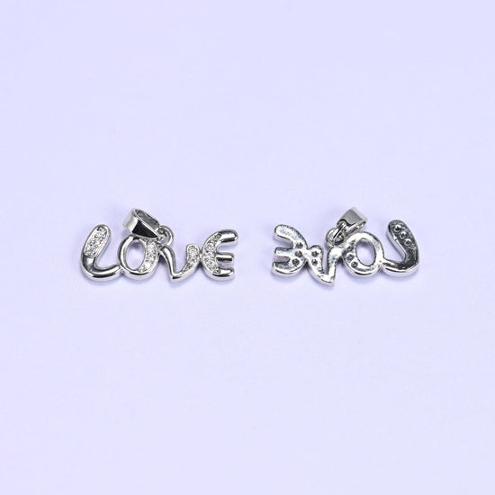 Silver-tone Love letter zirconia charms, one pendant face up and one turned over to show the smooth reverse side.