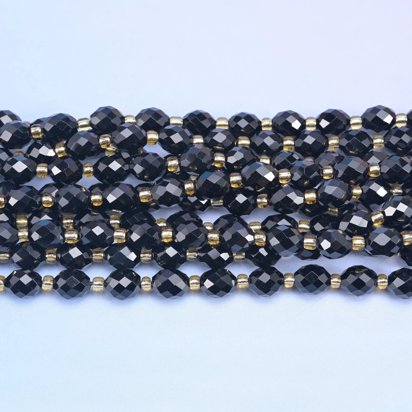 Black Onyx Faceted Rice Barrel Beads, sold per 15.5 inch strand.