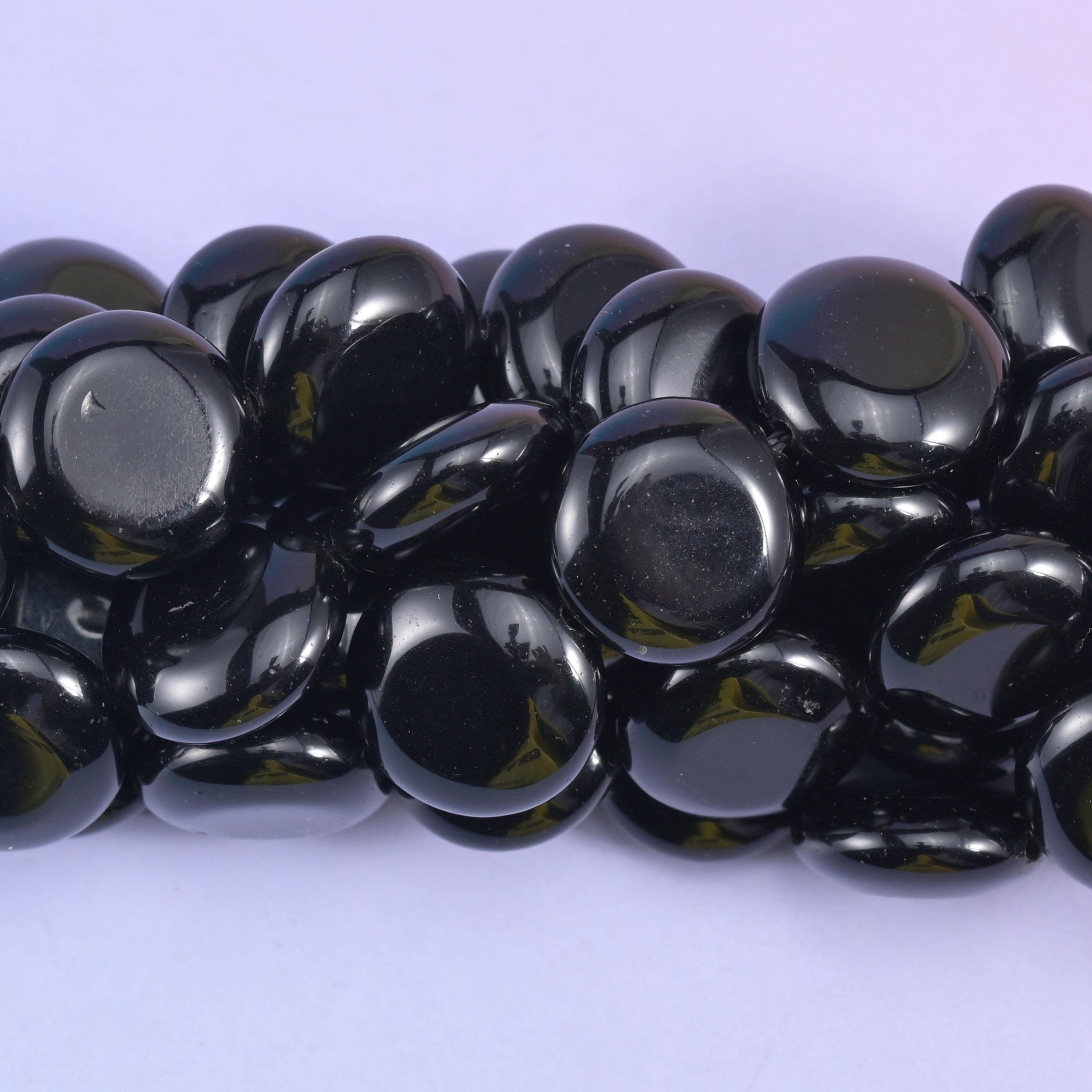 Macro crop of the polished coins where a green tint shows through the black at the thinner edges