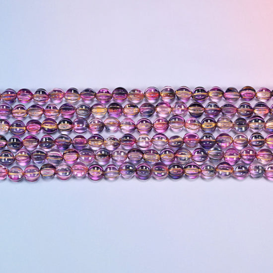 Close-up of 8mm pink blue gold pumpkin glass beads in four horizontal rows, showing the carved melon ribs.