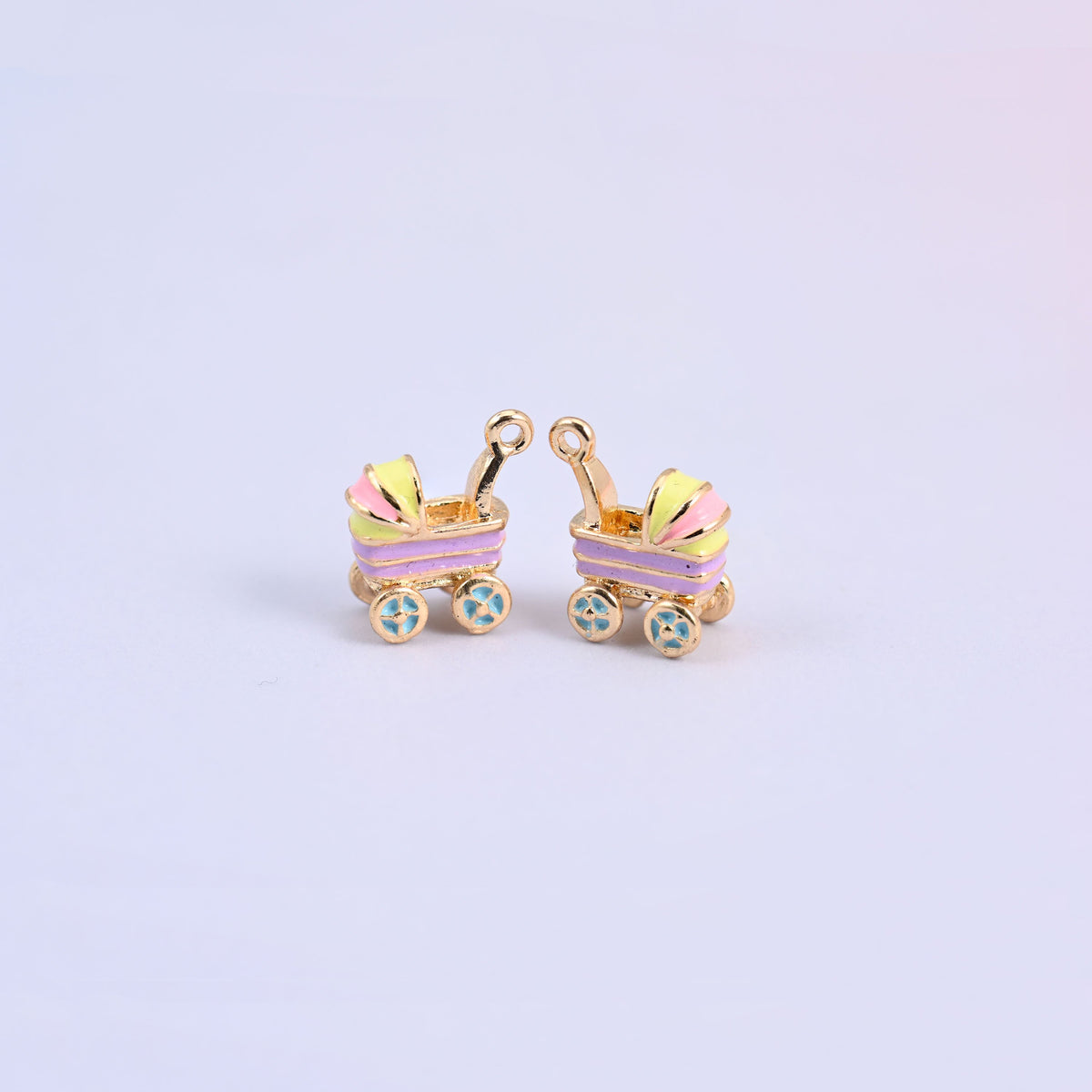 Two light purple stroller charms with yellow and pink striped hoods and light blue flower-spoke wheels.