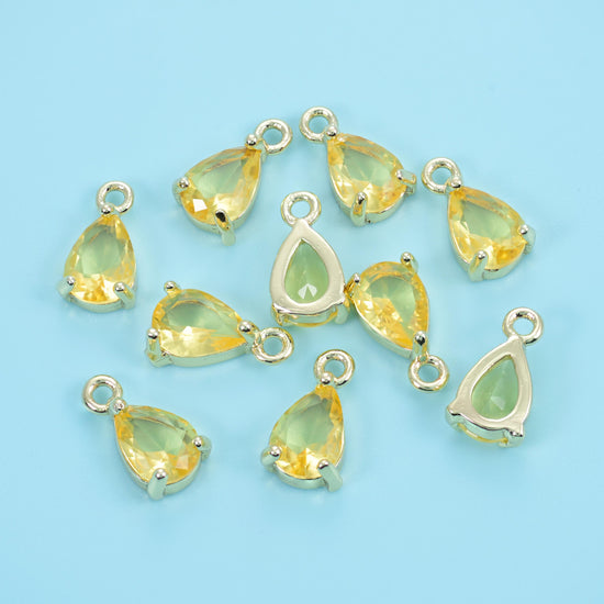 Teardrop zirconia charms in canary yellow, a scattered group of pear-cut stones.