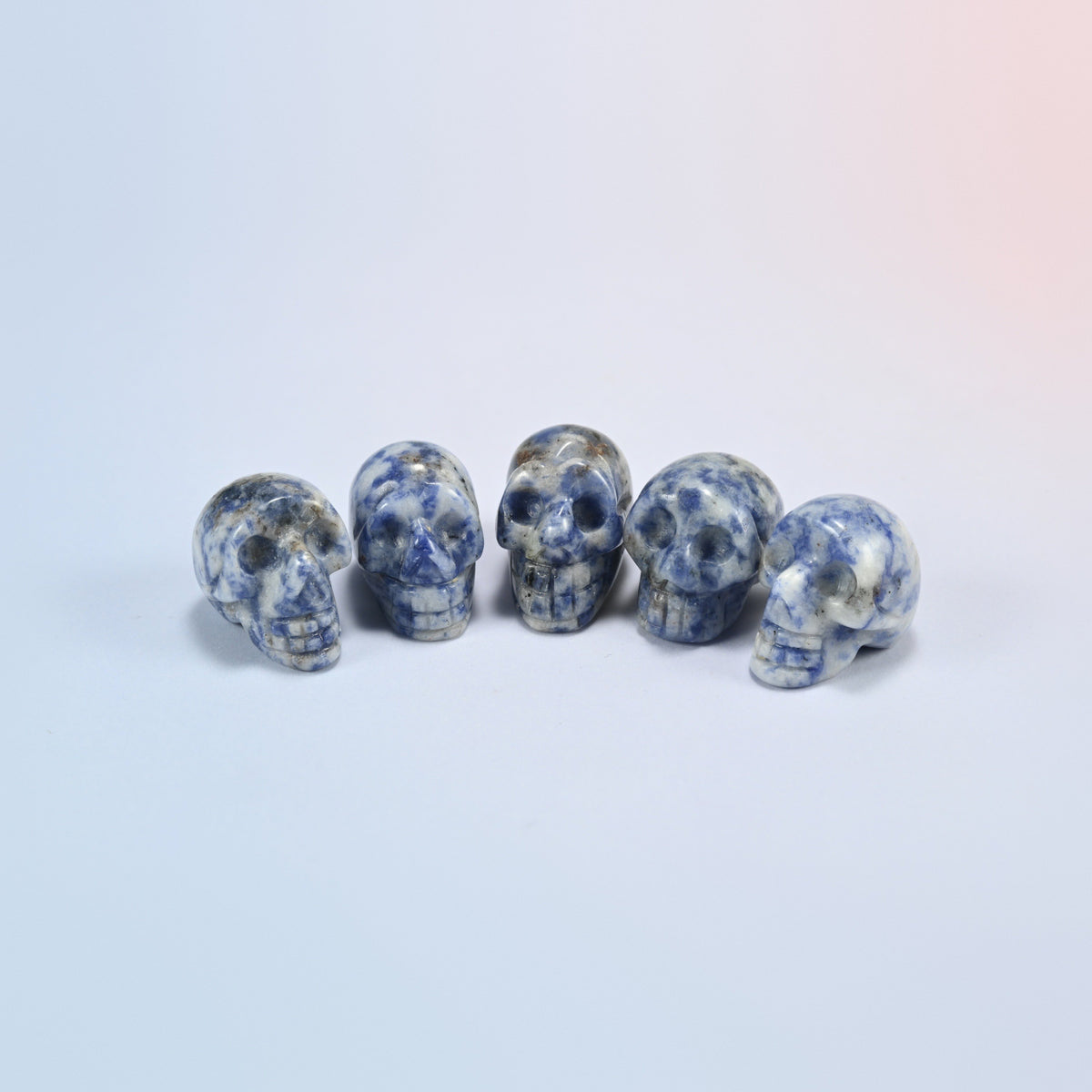 1 inch skull crystal carving in blue spot jasper, white natural stone with blue spots
