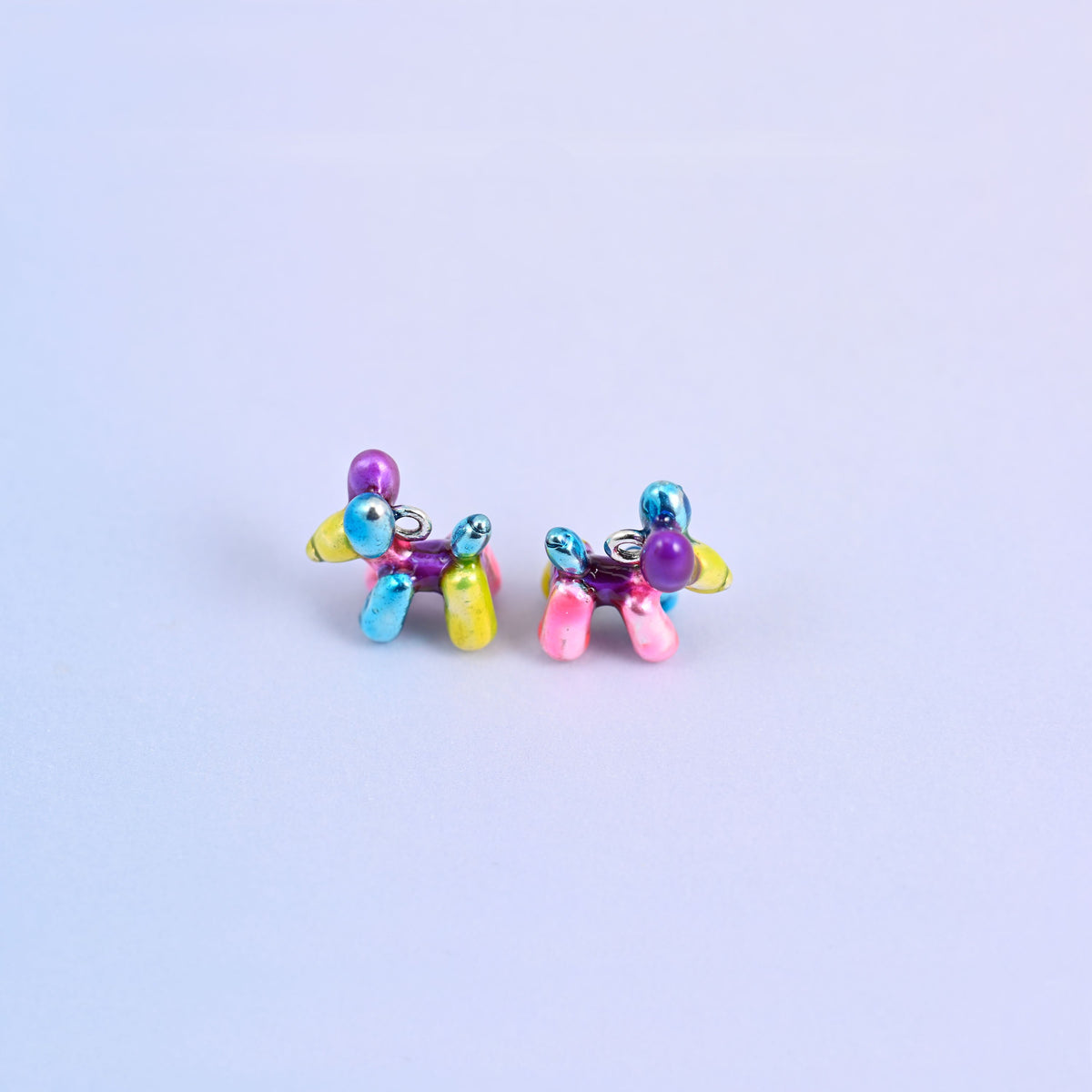 Balloon dog charms standing on their legs, purple head, blue ears and a pink and yellow body.