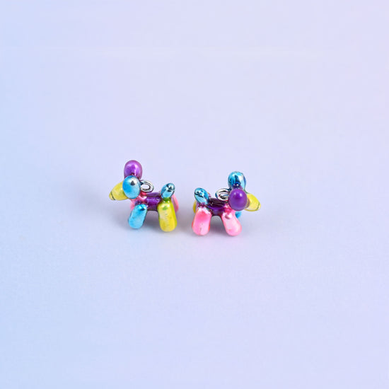 Balloon dog charms standing on their legs, purple head, blue ears and a pink and yellow body.
