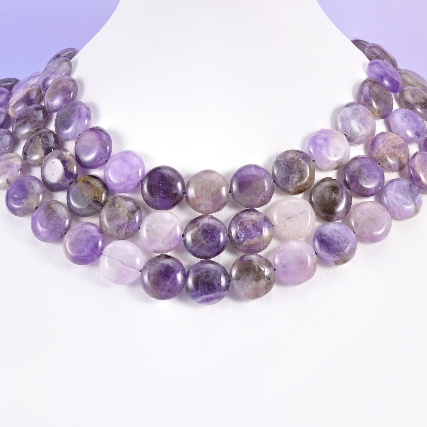 Amethyst coins layered in rows on a white neck display form