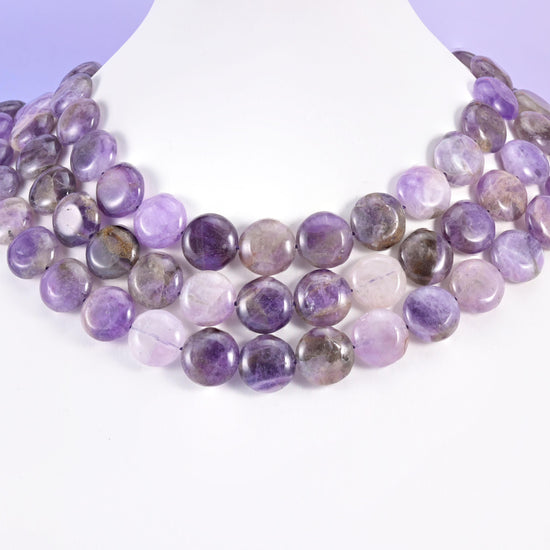 Amethyst coins layered in rows on a white neck display form
