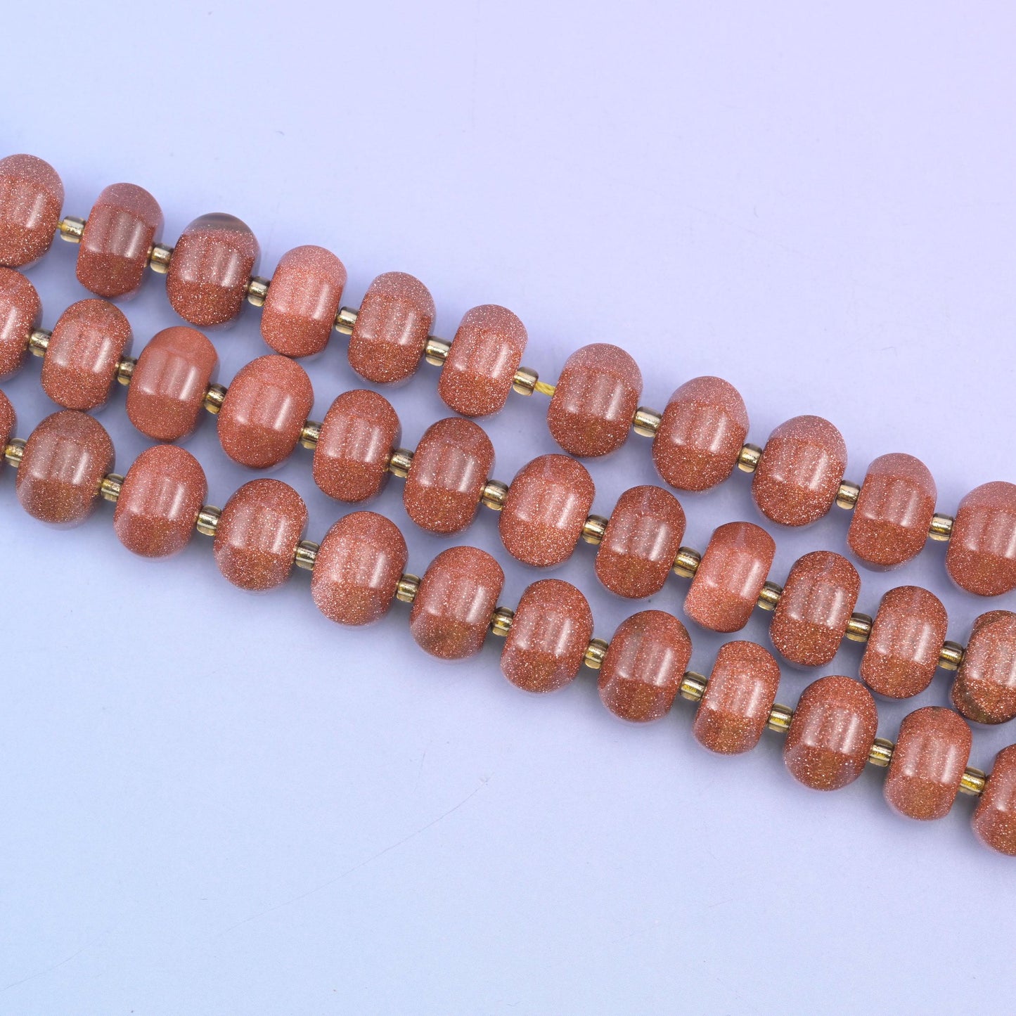 Gold sandstone beads in warm brown-red flecked with sparkling copper glitter