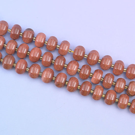 Gold sandstone beads in warm brown-red flecked with sparkling copper glitter