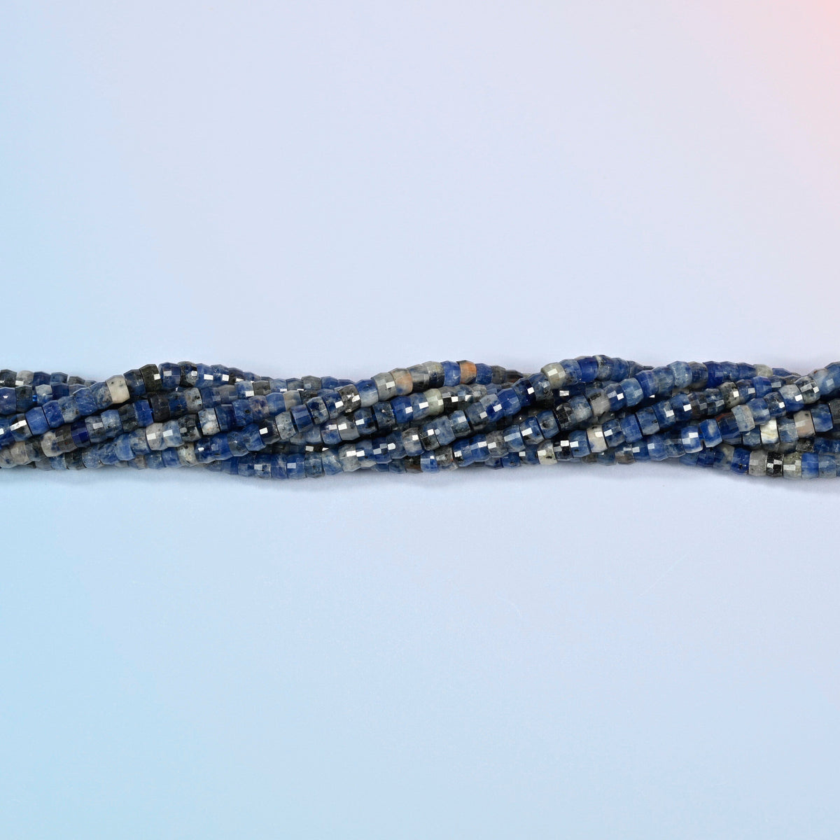 Strands of sodalite faceted heishi disc beads twisted together in a horizontal row