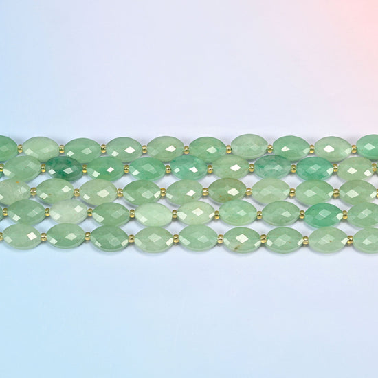 Several strands of green aventurine faceted flat oval beads laid in straight rows with gold seed bead spacers