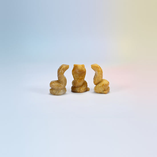 Cobra snake crystal carving in yellow jade, soft yellow natural stone