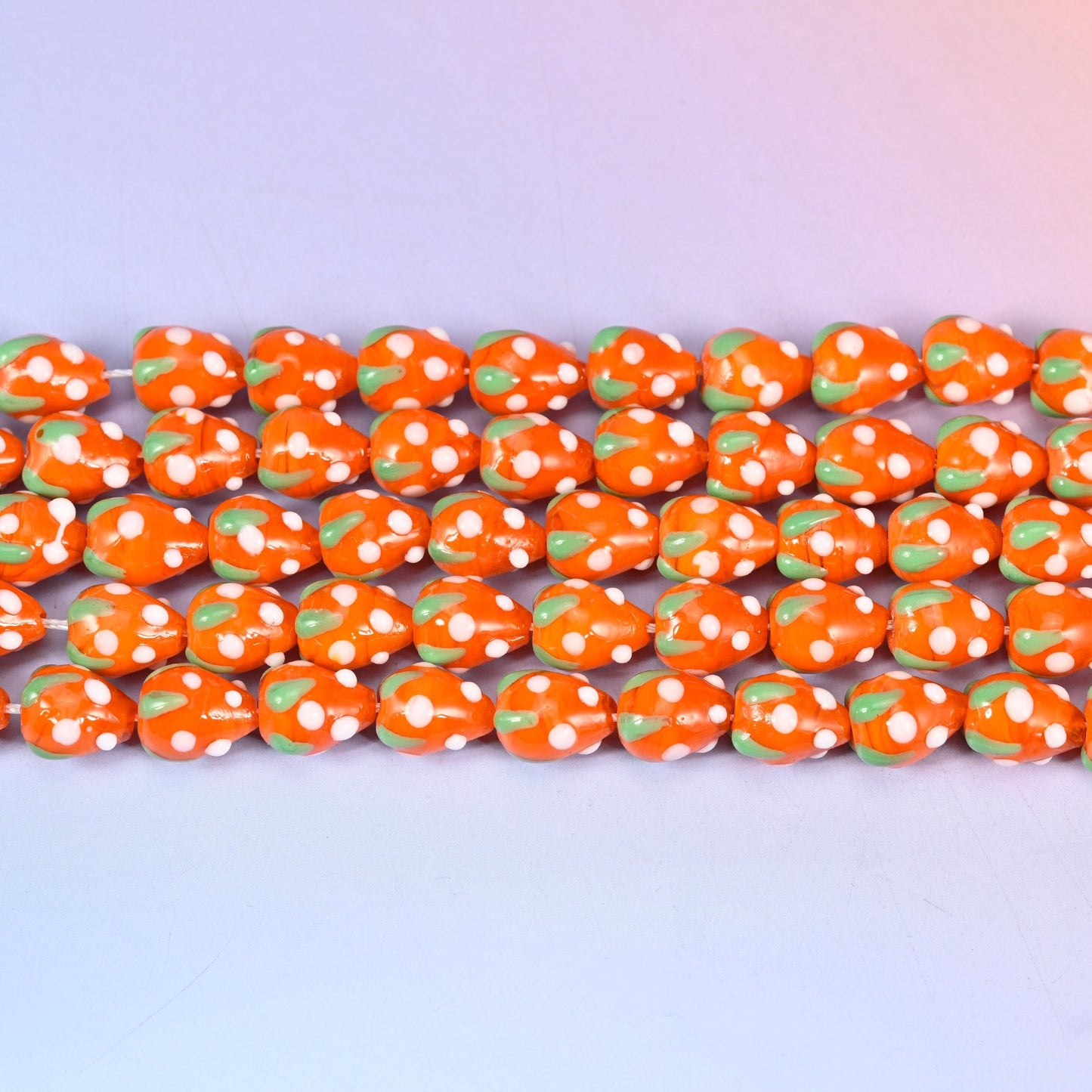 Orange White Dots Strawberry Glass Beads in bright glossy orange with a green leaf cap