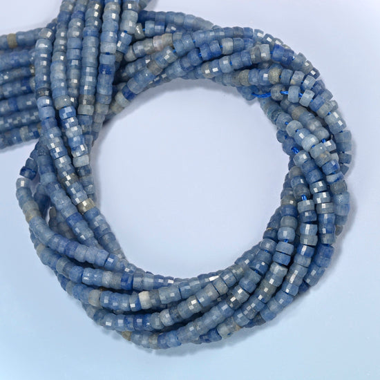 Blue aventurine faceted heishi disc beads coiled into overlapping loops, whole strands of soft light blue stone