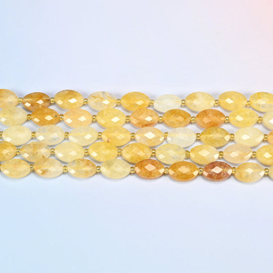 Several strands of golden healer quartz faceted flat oval beads laid in straight rows with gold seed bead spacers