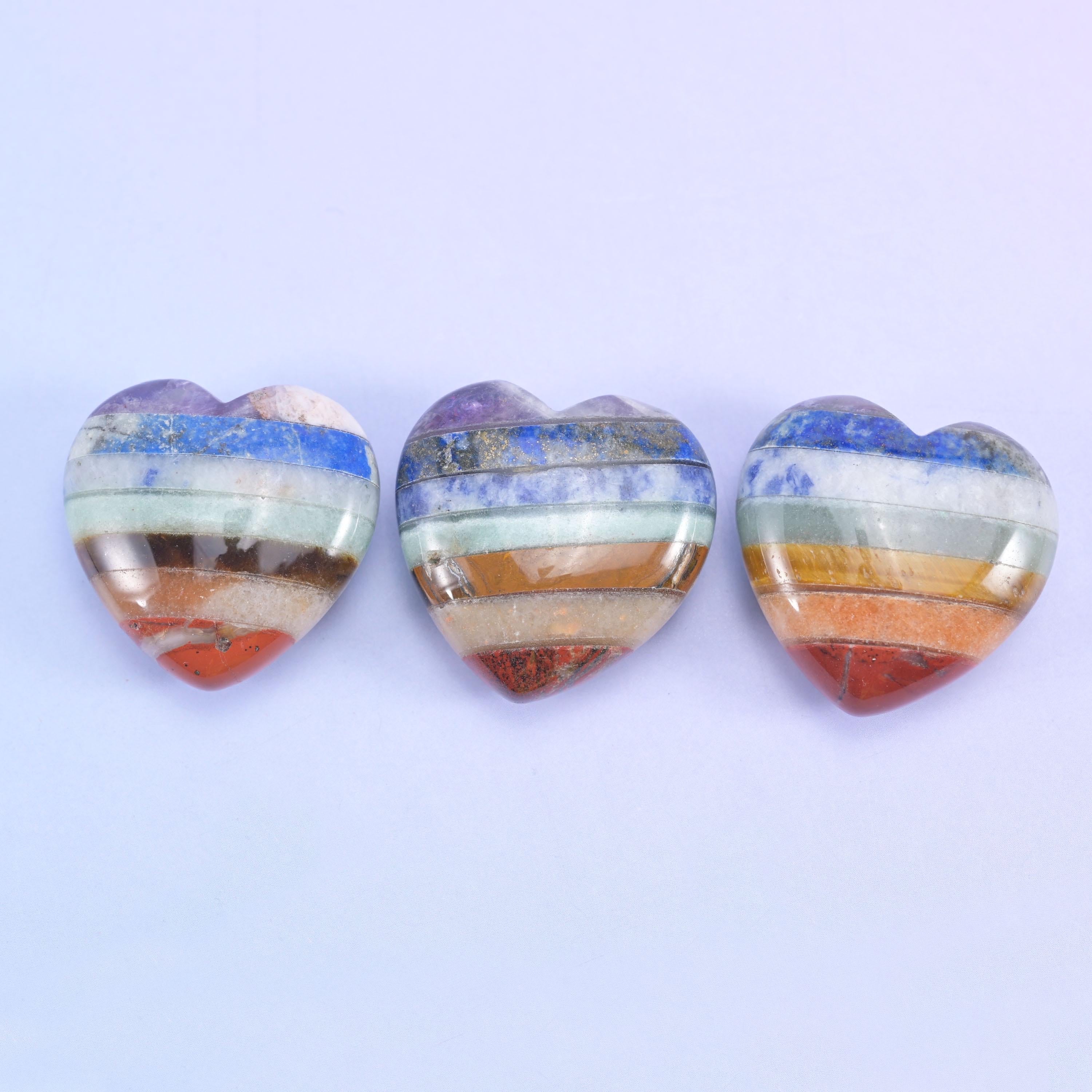 Three heart carvings side by side, showing how the colour stripes land differently across each one