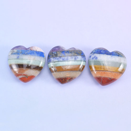Three heart carvings side by side, showing how the colour stripes land differently across each one