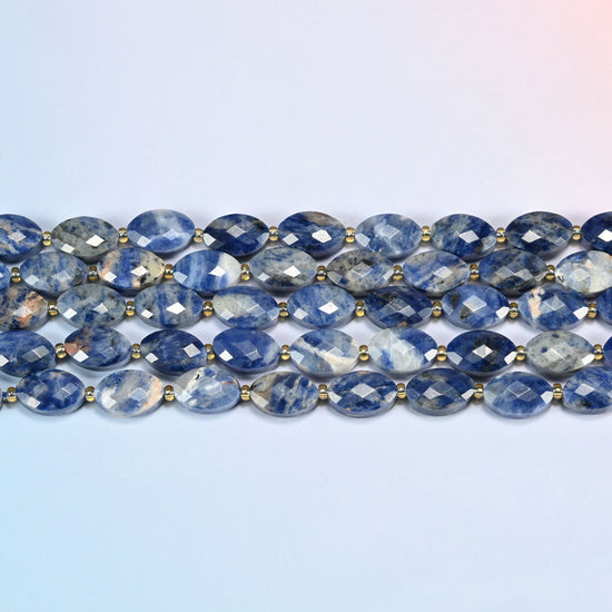 Several strands of orange sodalite faceted flat oval beads laid in straight rows with gold seed bead spacers