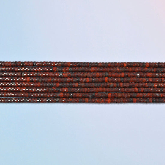 Several strands of Zhanguo red agate faceted heishi disc beads laid in straight rows
