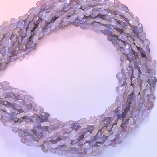Small puffed hearts in pale lilac and soft violet, lightly translucent with drifting bands of grey-beige and silvery mica flecks