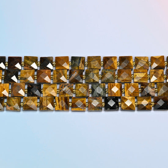 Several strands of natural tiger eye faceted flat square beads laid in straight rows