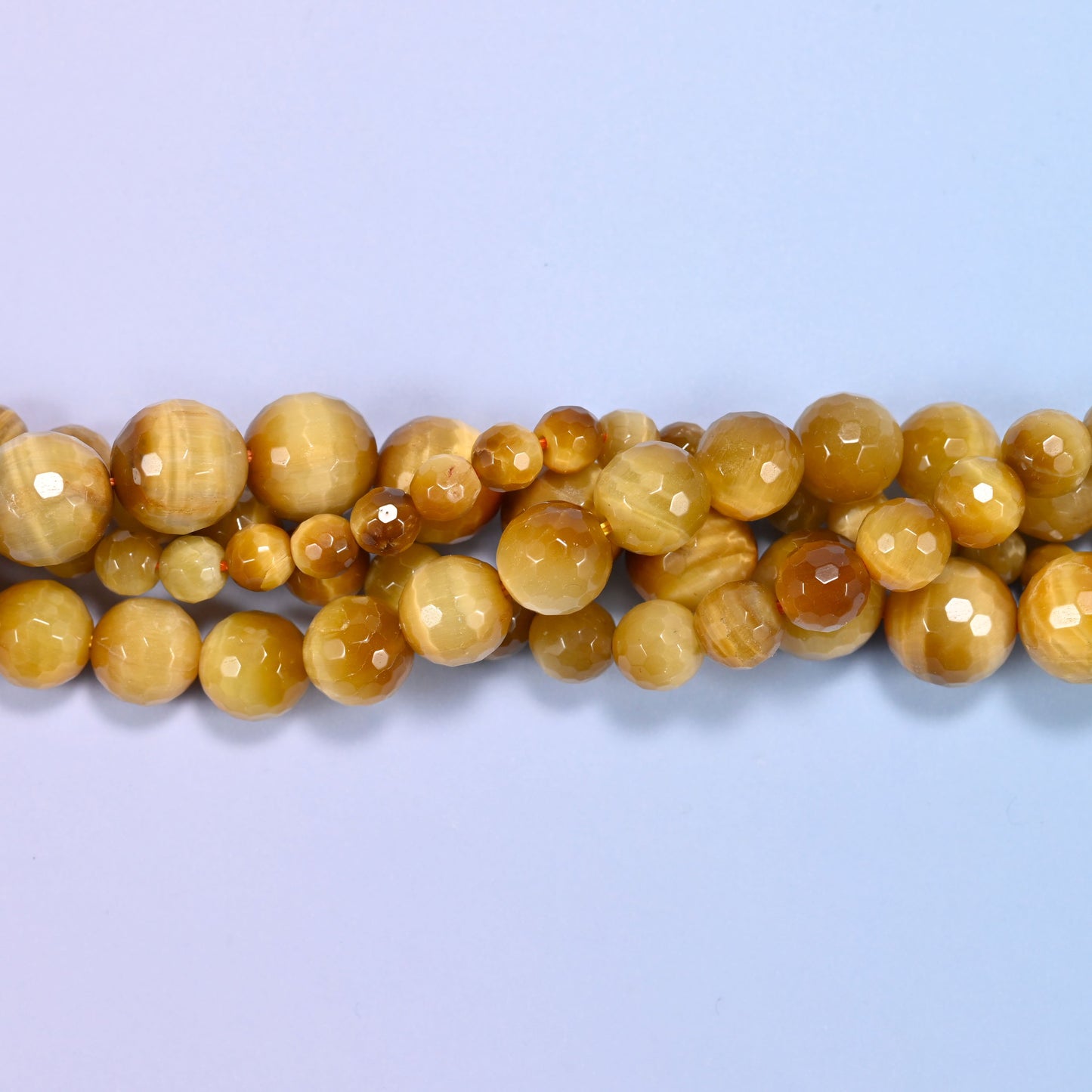 End detail of a golden brown gold tiger eye beaded strand (15-inch strand), showing bead spacing.