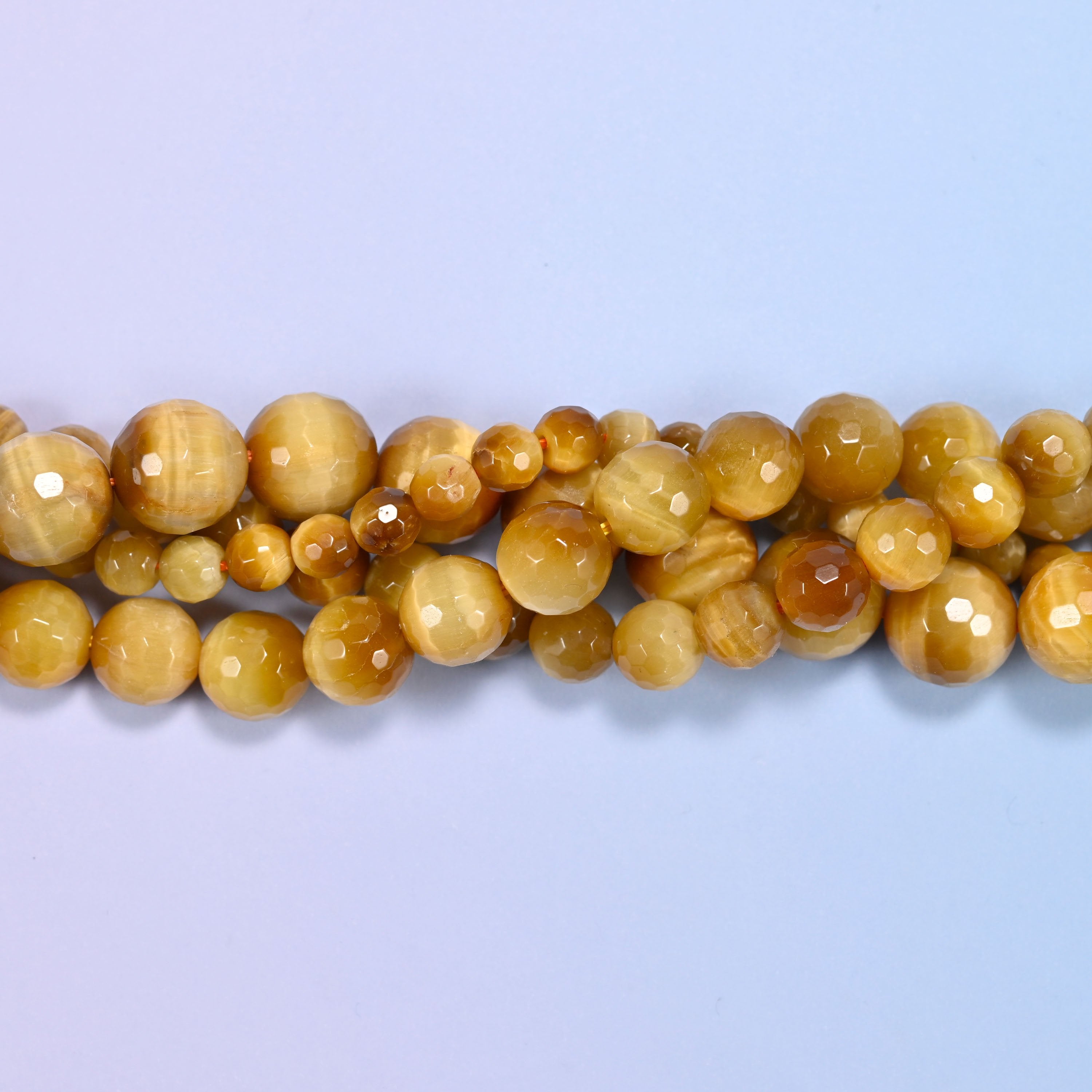 End detail of a golden brown gold tiger eye beaded strand (15-inch strand), showing bead spacing.