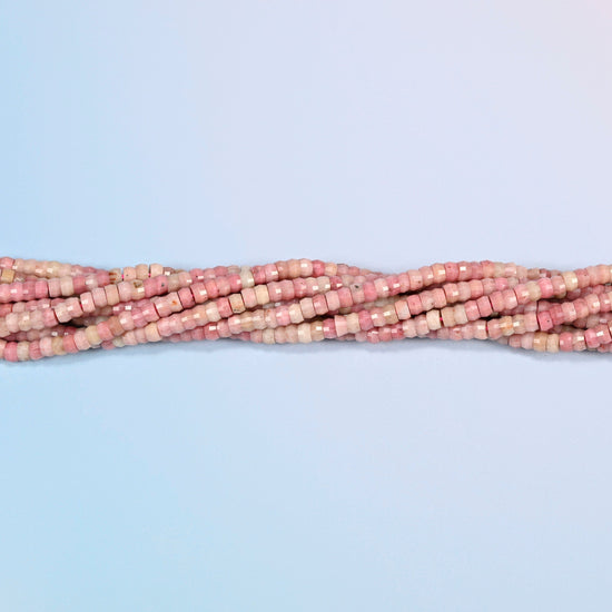 Strands of pink rhodonite faceted heishi disc beads twisted together in a horizontal row