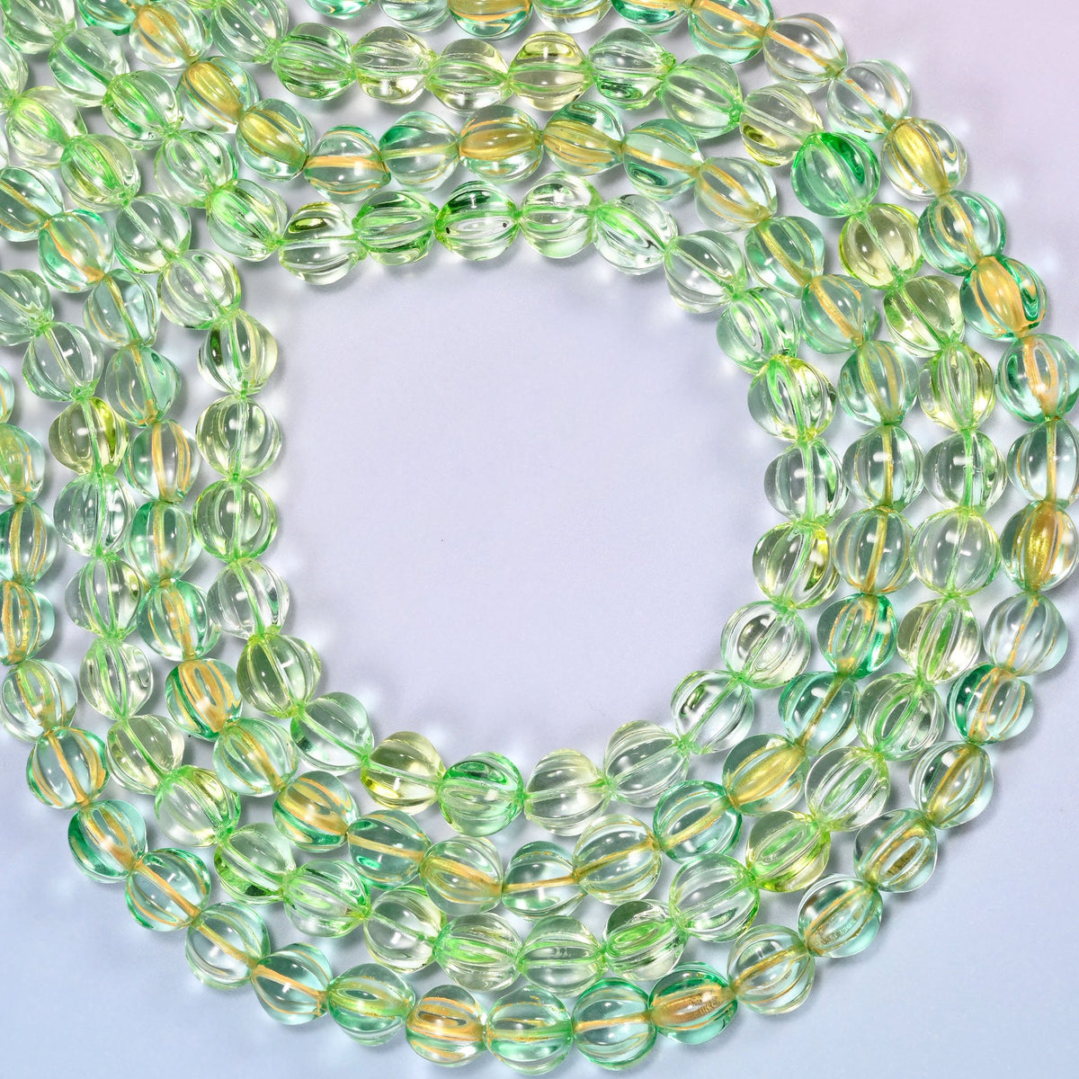 Green gold pumpkin glass beads coiled into a wide open ring, gold ribs catching the light.