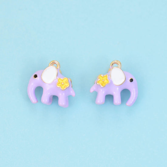 A little elephant in soft pastel enamel — dusty pink or lilac purple — with a cream-white ear, a dot of a dark eye and a…