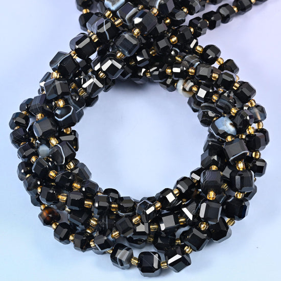 Dyed Black Strip Agate Faceted Cube Beads with tiny gold seed spacers lifting the dark stone