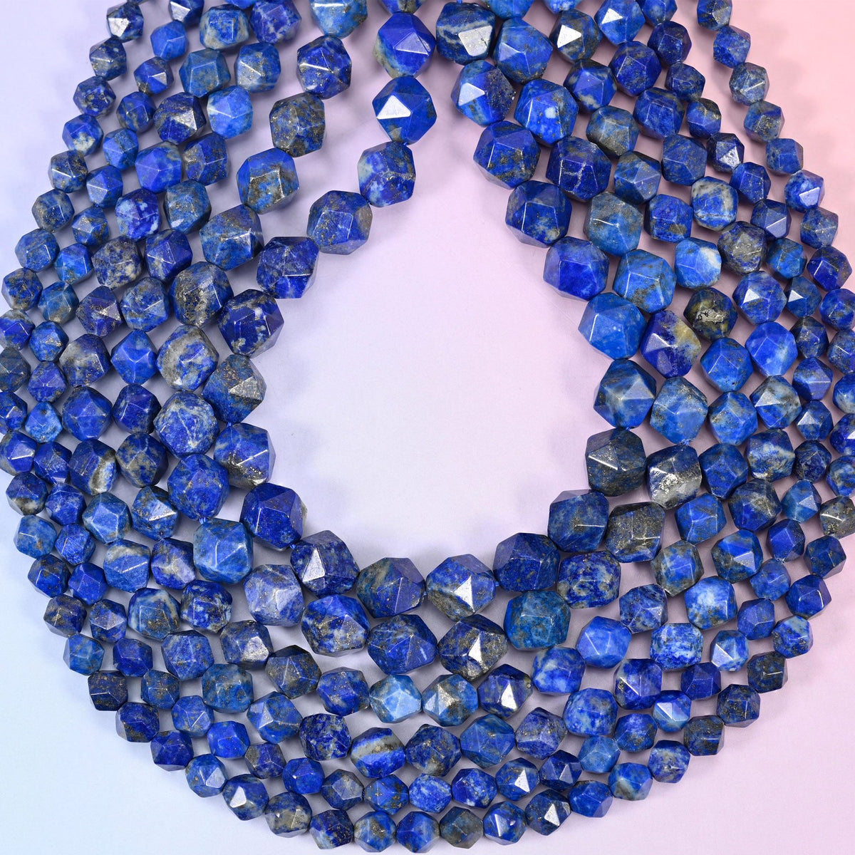 Blue Lapis Lazuli beads coiled into a loop, star facets throwing sharp white highlights across the royal blue