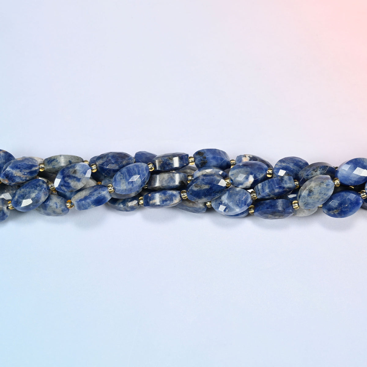 Strands of orange sodalite faceted flat oval beads twisted together in a horizontal row