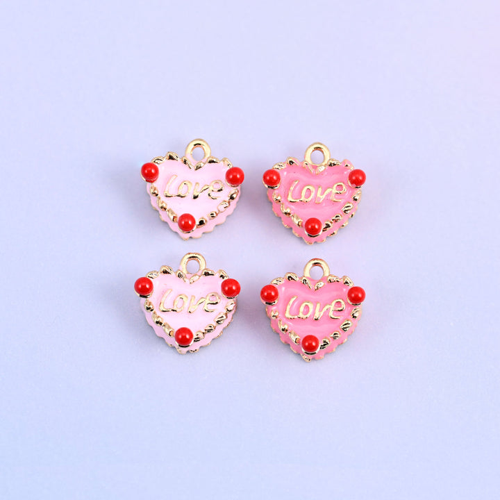 Four enamel heart charms in pink and light pink, 18K gold plated brass with a raised gold Love script and red bead accents.